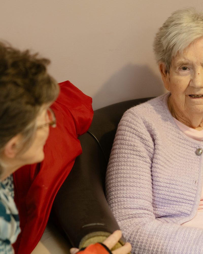 Two older women sitting together and talking